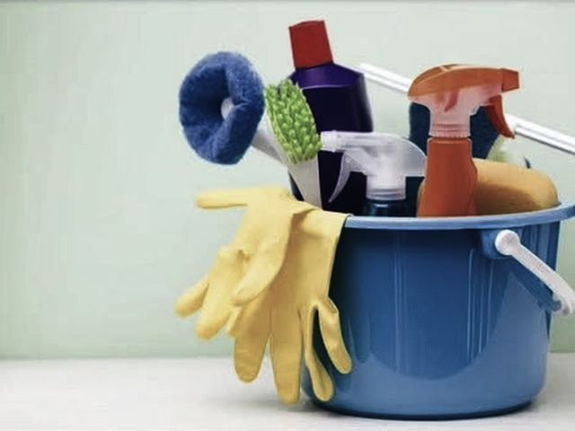 A bucket of cleaning supplies, cloths and gloves ready for a shift